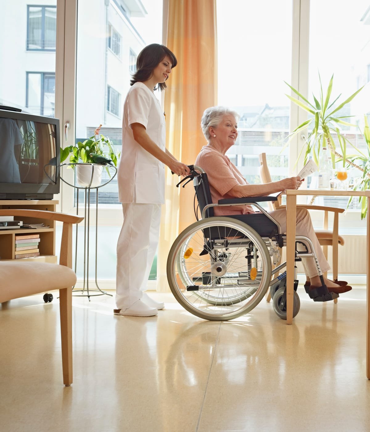 Seniori citind ziarul într-un spațiu luminos